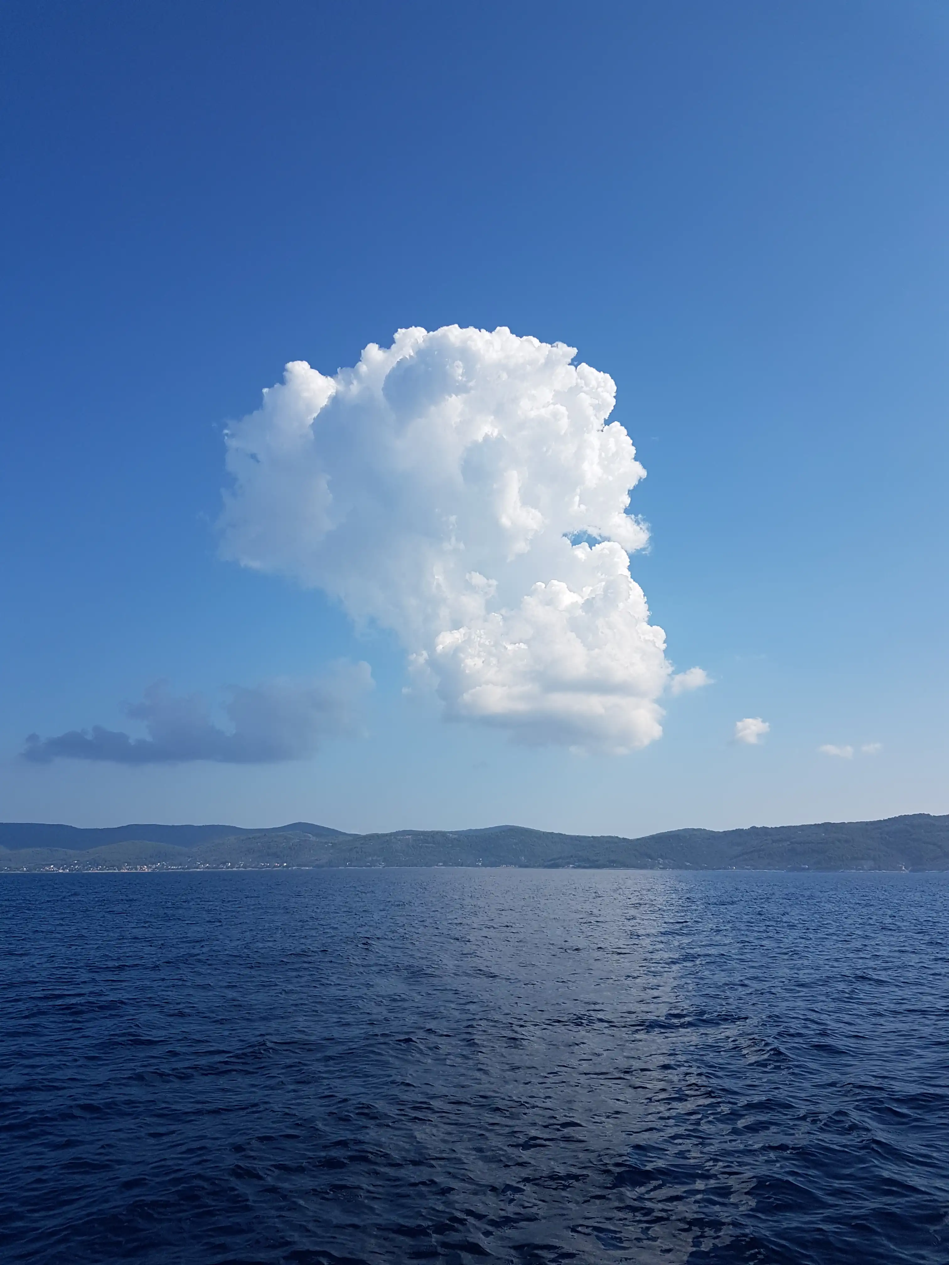 Two funy lookig cloads above the sea.